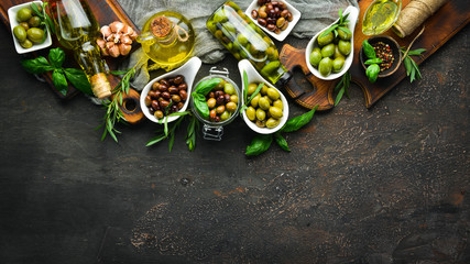 Olives, olive oil, spices and herbs on the Rustic background. Top view. Free space for your text.