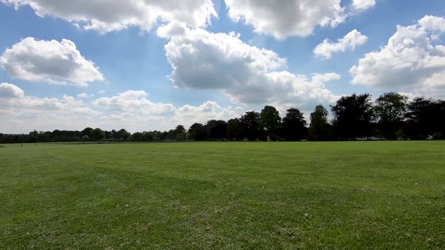 Hyper lapse walk across a wide area of grass land in the war memorial park in Coventry