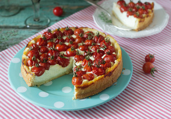 Tart, pie or cheesecake with cottage cheese and tomatoes, served with red wine on a wooden background.