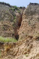 Landslide zone on Black Sea coast. Rock of sea rock shell. Zone of natural disasters during rainy season. Large masses of earth slip along slope of hill, destroy houses. Landslide - threat to life