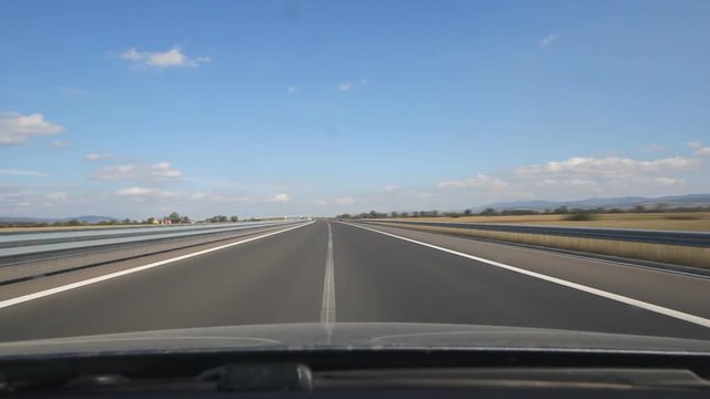 Fast motion drive with high speed on empty highway, front view through windscreen