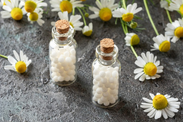 Bottles of homeopathic pills with chamomile flowers