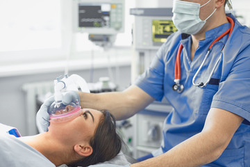 Several doctors surrounding patient on operation table during t