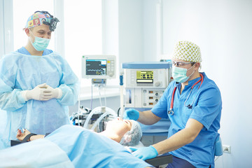 Several doctors surrounding patient on operation table during t