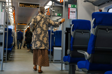 Moscow, Russia - May, 9, 2019: image of an old woman holding a handrail in a subway car