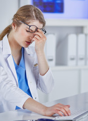 Young female doctor tired after working with computer