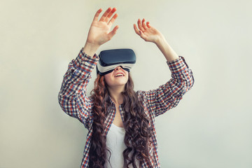 Smile young woman wearing using virtual reality VR glasses helmet headset on white background. Smartphone using with virtual reality goggles. Technology, simulation, hi-tech, videogame concept
