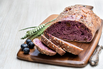 Blueberry and chia seed bloomer on white wooden table