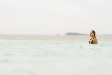 Portrait beautiful young asian woman wear bikini around swimming pool in hotel resort nearly sea ocean beach