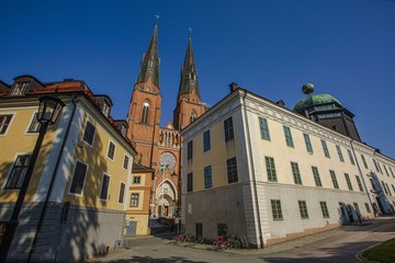Beautiful view on cathedral church between old buildings on blue sky background. Europe.Sweden. Uppsala