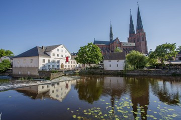 Fototapeta na wymiar Beautiful view of beutiful white houses and cathedral church reflecting on the water surface. Gorgeous nature landscape backgrounds.