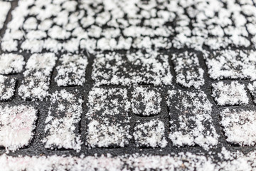 Macro closeup of doormat covered in winter snowflakes