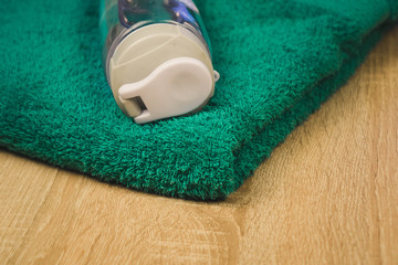 water bottle and turquoise towel on wooden background.