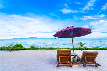 Beautiful landscape of beach sea ocean with empty chair deck and umbrella nearly coconut palm tree with white cloud and blue sky