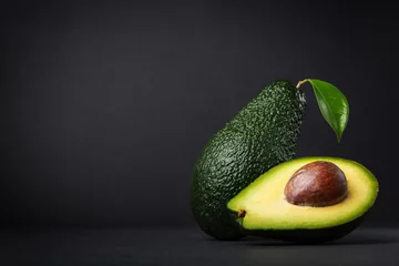 Foto op Plexiglas Fresh, raw avocado on a black background © Nataliia