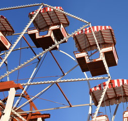 Riesenrad mit offenen Kabinen vor strahlend blauem Himmel