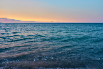 Obraz premium Waves on a pebble beach on a sunset. Natural background.
