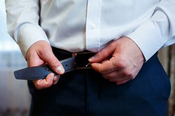 A man puts on a men's suit on the day of the wedding