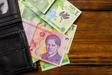 Various Romanian banknotes on a wooden table, 1-5 leu and a wallet. Europe Hungary.