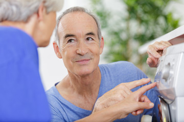 portrait of a happy senior couple in washing clothes