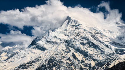 Obraz premium Mountain peaks with glaciers and snow and white clouds, Annapurna region in Himalayas