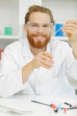 young interested scientist keeping and overlooking test tube