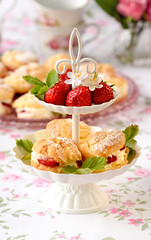tuł Cream puffs cakes or profiterole filled with whipped cream served with strawberries in plateau