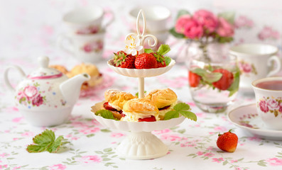 tuł Cream puffs cakes or profiterole filled with whipped cream served with strawberries in plateau