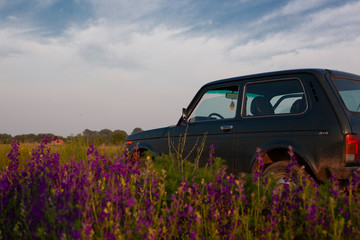 off-road vehicle in nature on an ancient dusty road and remote houses