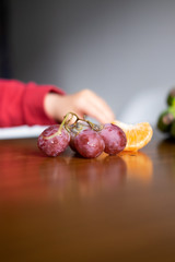 Baby s hand manipulating different fruits on a wooden table