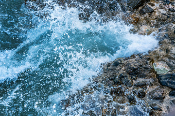 Sea foam on the rocky shore. Close-up, background. Space for text.