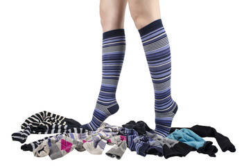 The legs of the girl stand on toe-toes on the side, dressed in blue striped knee-length socks