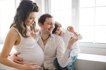 Happy family waiting for a second child. Pregnant woman with husband and little boy . Second...