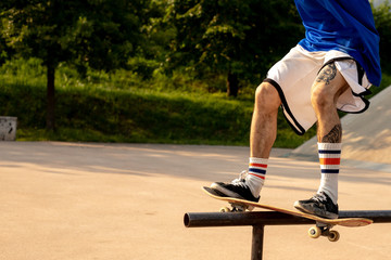 Skater doing a "frontside feeble" grind on rail in skate park. close up on legs