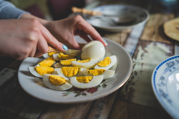 Close up on female hands woman girl cutting boiled egg at home domestic farm natural healthy organic food