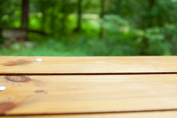 Wooden table sitting outside a blurry forest