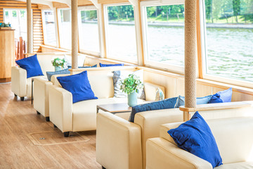 The interior of the urban river ship, with a panoramic view of the urban landscape. The concept of tourism, recreation, walking around the city, rest in the city. River transport.