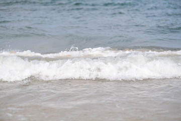 closeup on waves hitting the beach on a sunny summer day