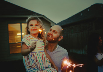 Father and Daughter doing firework sparklers together