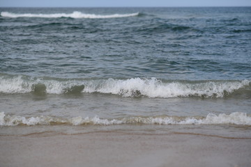 closeup on waves hitting the beach on a sunny summer day