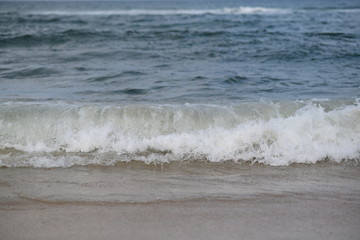 closeup on waves hitting the beach on a sunny summer day