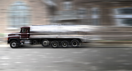 A Milk truck car at high speed rides along the road, speed in motion