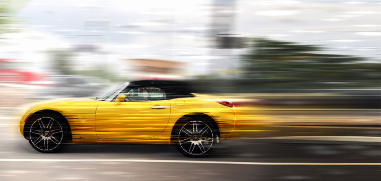A yellow car at high speed rides along the road, speed in motion