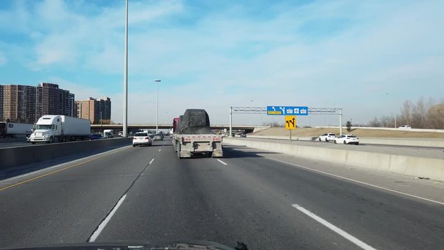 Passing Large Flatbed Trucks On Highway While Driving Underneath Bridge Overpass Interchange