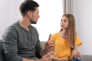 Father talking with his teenager daughter at home