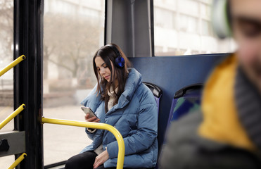 Young woman listening to music with headphones in public transport