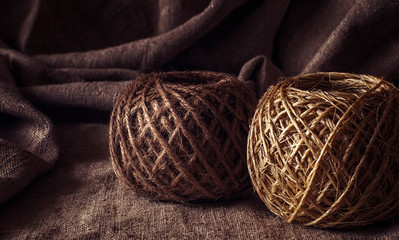 A coil of old, coarse, woolen thread. Vintage. A string of packing twine. The background is made of...