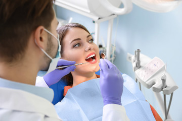 Professional dentist working with patient in modern clinic