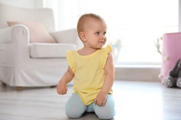 Cute baby girl on floor in room