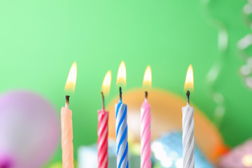 Burning birthday cake candles on color background. Space for text